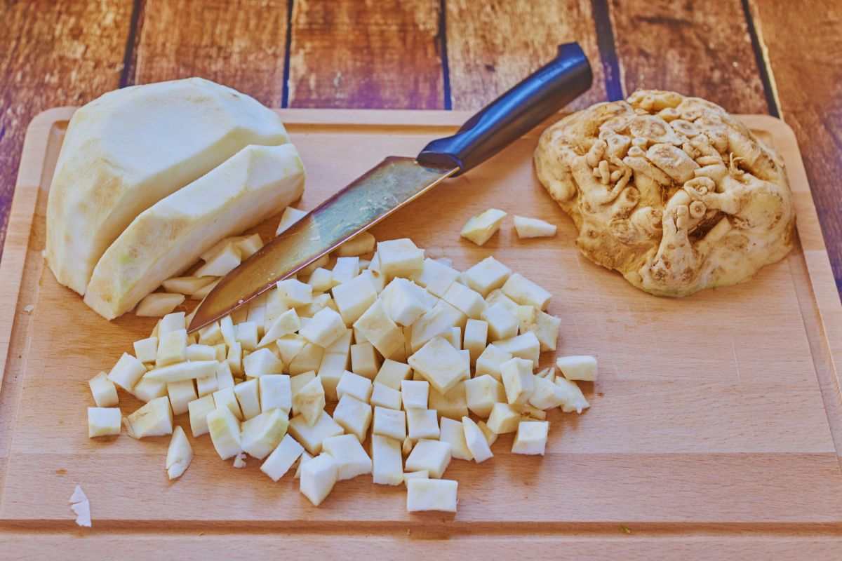 un tagliere con un coltello e sedano rapa lavorato